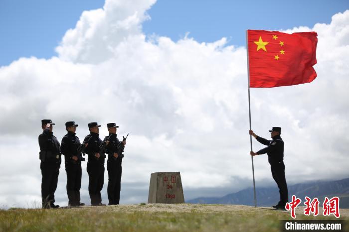 图为亚热边境派出所民警在中尼边境界桩向国旗敬礼。(资料图) 何宇恒 摄